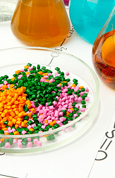 Close-up of brown composite decking steps with grooved wood-grain texture and black risers meeting at a corner.